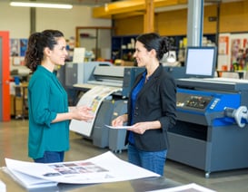 Firefly_young female graphic designer and print production manager discussing project in fron 8390