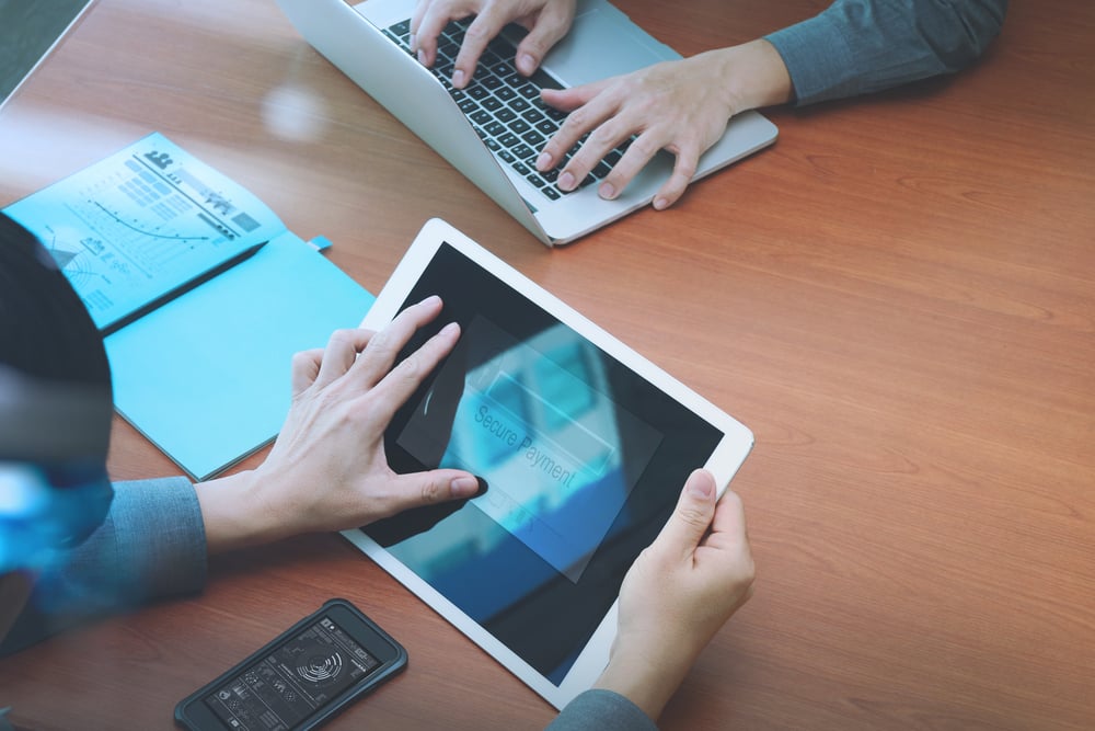 top view of two colleagues using digital pro tablet and laptop computer with Secure payment on the screen as Online shopping concept